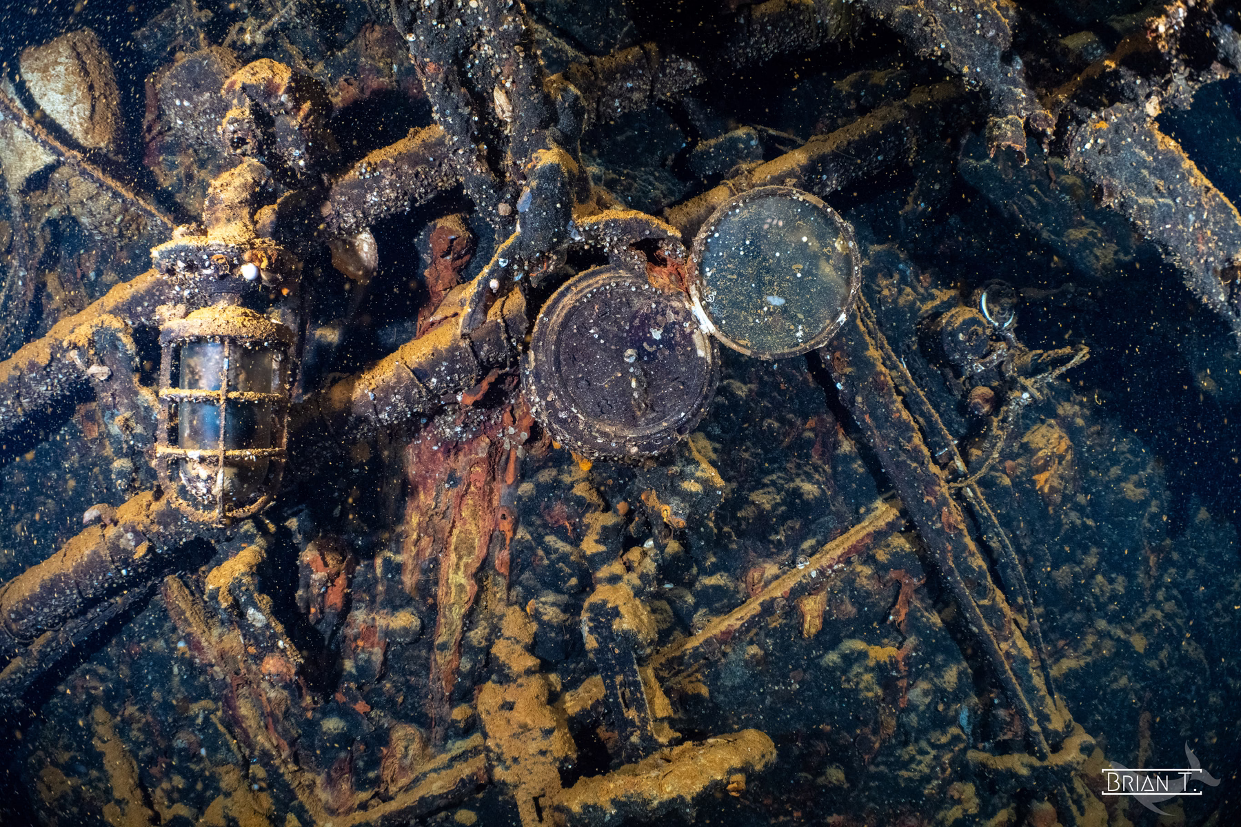 A pocket watch, compass and bottles among the wreckage of a Truk ship