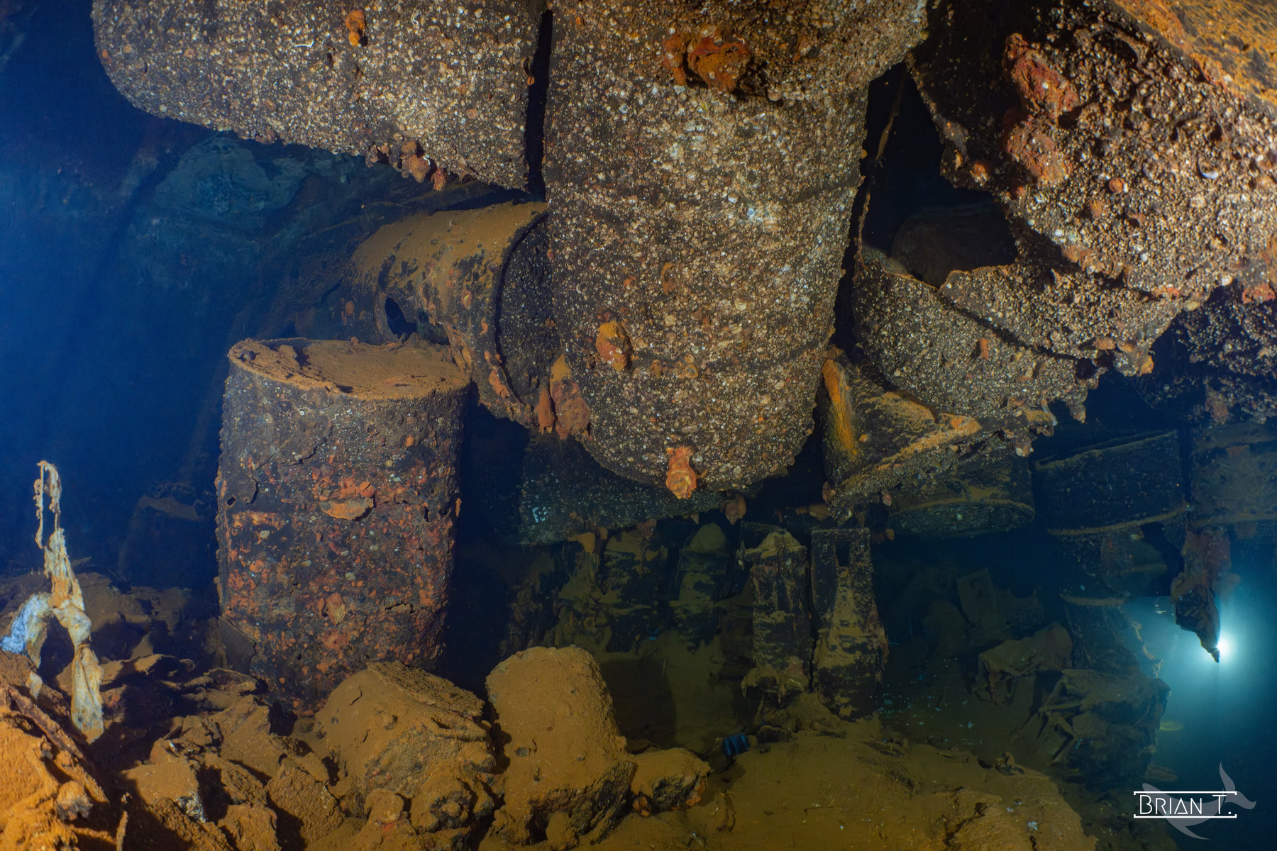 A diver's light deep inside the engine room of a shipwreck