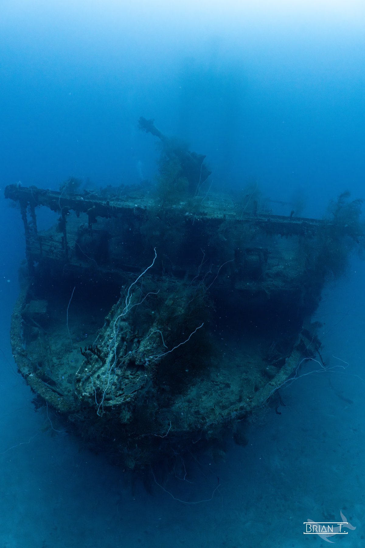 The ghostly bow of a shipwreck fading into the blue haze of Truk Lagoon