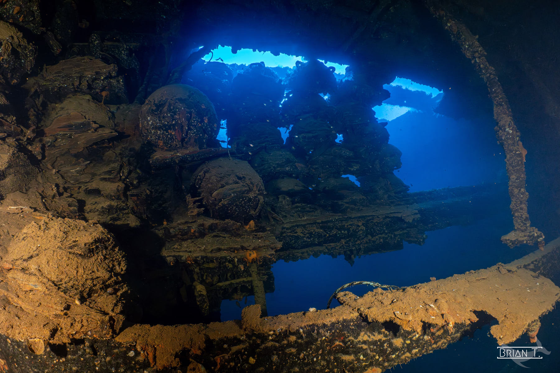 Shafts of light falling through openings into the dark interior of a wreck